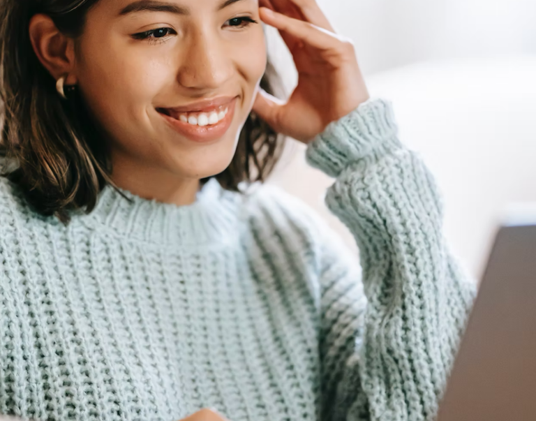 person smiling at laptop